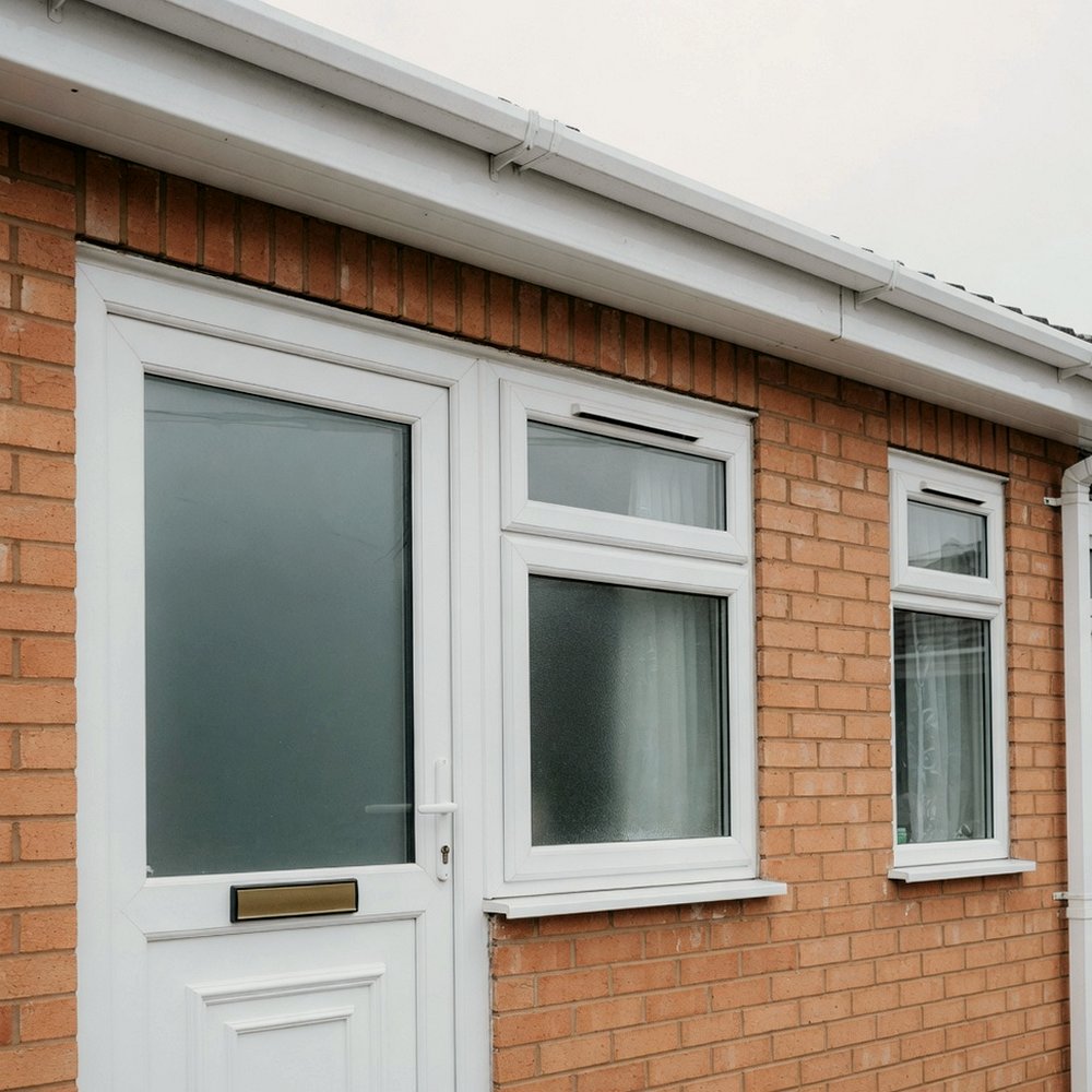 White UPVC door, windows and fascia on a brick bungalow